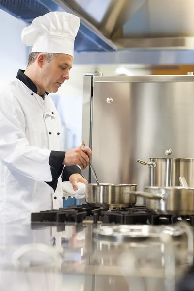 Concentrating head chef stirring in pot — Stock Photo, Image