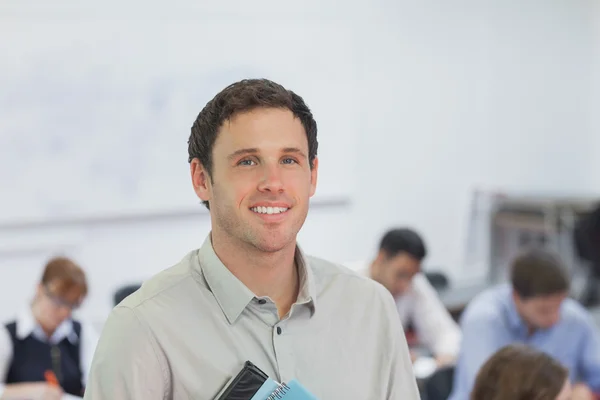 Bonito professor masculino em pé em sua sala de aula — Fotografia de Stock