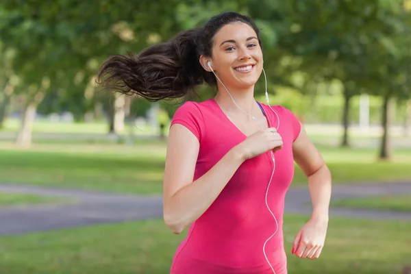 Motiverade vacker kvinna jogging i en park — Stockfoto