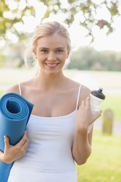 Jovem feliz segurando um tapete de exercício — Fotografia de Stock