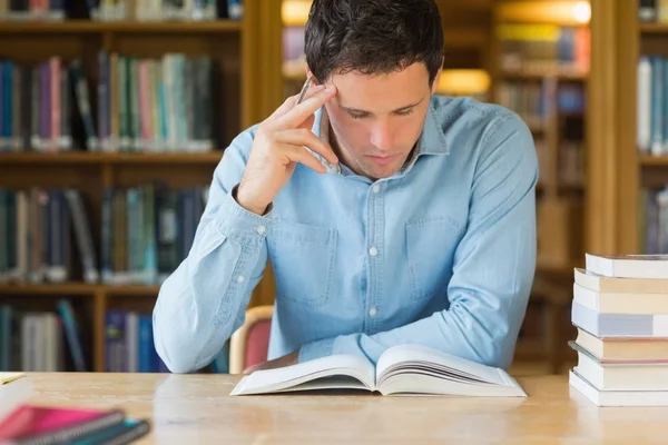 Allvarliga mogen student som studerar på biblioteket skrivbord — Stockfoto