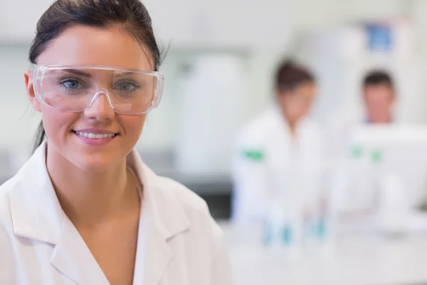 女性研究员在实验室背景的同事 — 图库照片