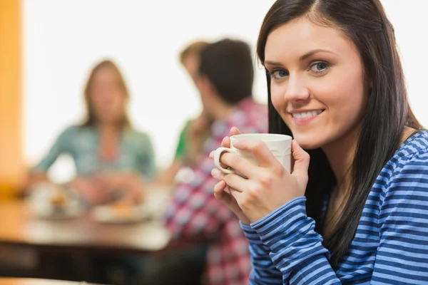 Πορτρέτο του ένα χαμογελαστό γυναίκα πίνοντας καφέ σε καφετέρια — Stock fotografie