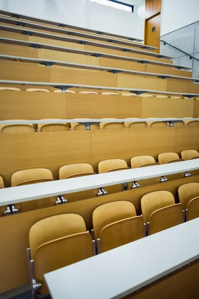 Empty seats with tables in a lecture hall — Stock Photo, Image