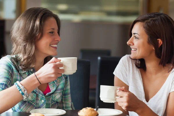 Два улыбающихся студента пьют кофе — стоковое фото
