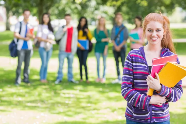 College meisje houdt van boeken met studenten in park — Stockfoto