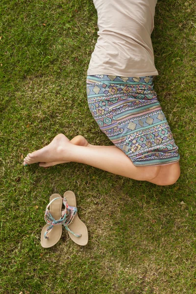 Женщина отдыхает на траве в парке — стоковое фото