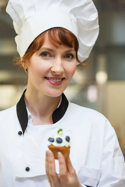 Ganska leende köksmästare håller blåbär dessert — Stockfoto