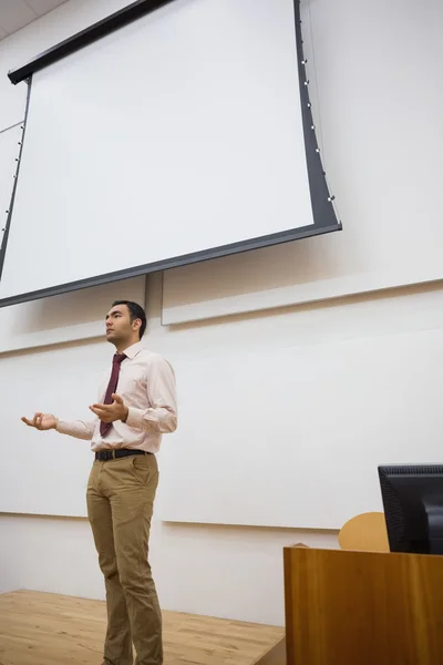 Чоловічий вчитель проти проекційного екрану в лекційній залі — стокове фото