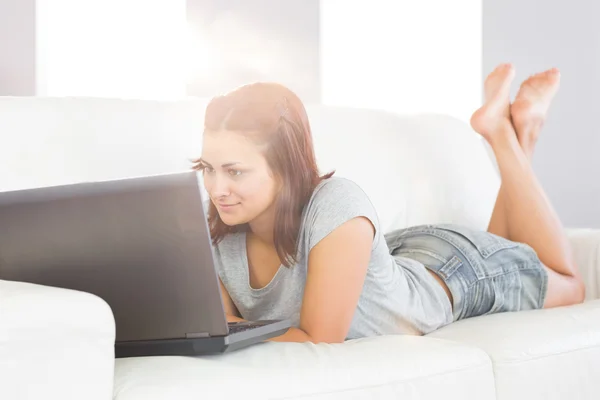 Content brunette woman lying on her white couch — Stock Photo, Image