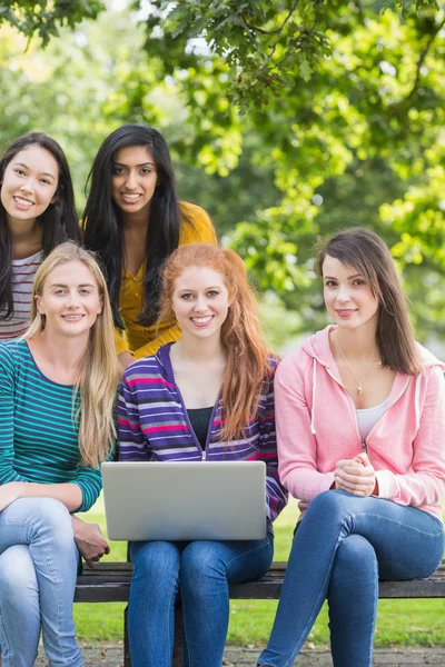 Unga collegeflickor med laptop i park — Stockfoto