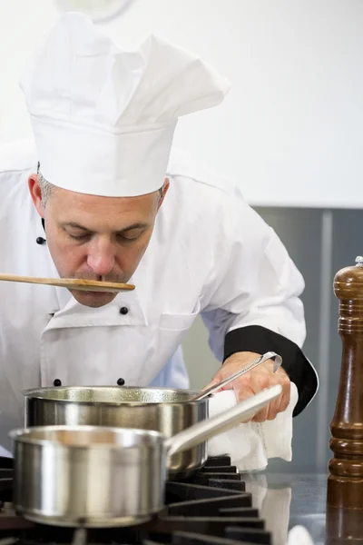 Concentración de chef jefe degustación salsa con cuchara de madera — Foto de Stock