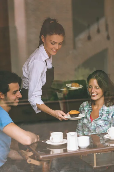 微笑的女服务员服务食物给一对夫妇 — 图库照片