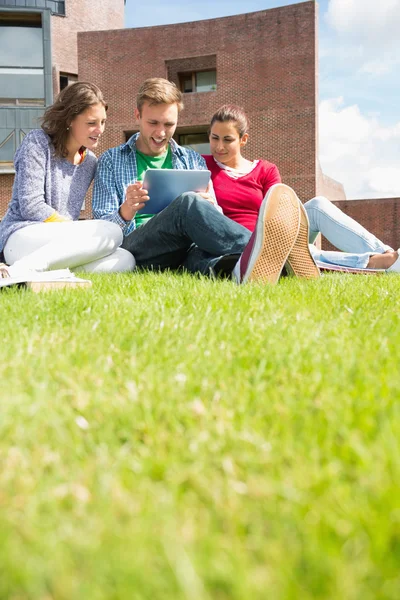 Students using tablet PC in the lawn against college building — Stock Photo, Image