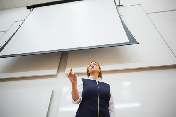 Elegante insegnante con schermo di proiezione in aula magna — Foto Stock