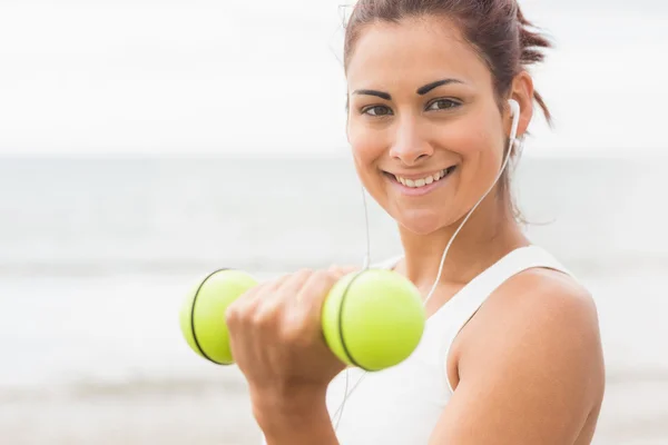Calm sporty woman lifting dumbbells smiling at camera — Stock Photo, Image