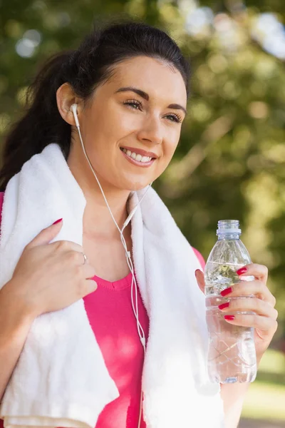 Mujer deportiva feliz usando ropa deportiva sosteniendo una botella —  Fotos de Stock