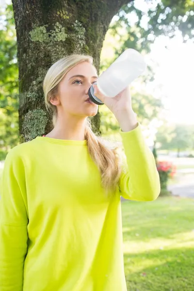 Fit calm blonde drinking from sports bottle — Stock Photo, Image