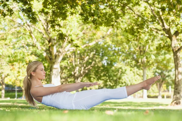 Güzel kadın bir parkta yoga yaparken yan görünüm — Stok fotoğraf