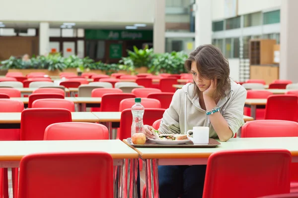 Studente triste seduto in mensa con vassoio di cibo — Foto Stock