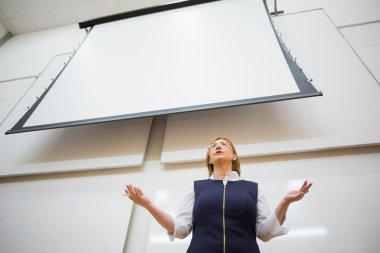 Female teacher with projection screen in the lecture hall clipart