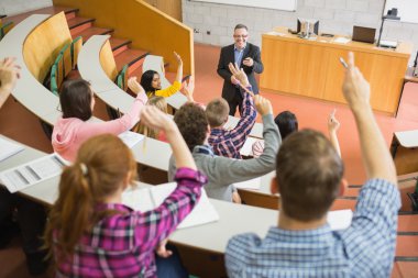Students raising hands with teacher in the lecture hall clipart