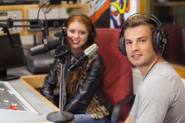 Attractive cheerful radio host interviewing a guest clipart
