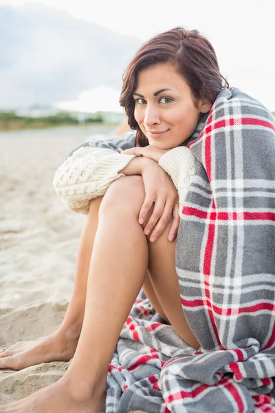Kvinna täckt med filt på stranden — Stockfoto