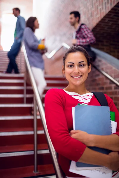 Souriant femmes tenant des livres avec des étudiants dans les escaliers à l'université — Photo