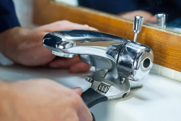 Close up of plumber repairing tap — Stock Photo, Image