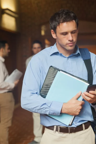 Serieuze knappe volwassen student gebruikend zijn smartphone — Stockfoto