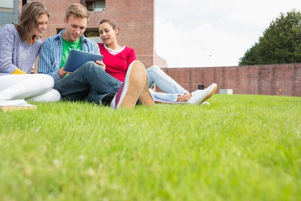 Students using tablet PC in the lawn against college building — Stock Photo, Image