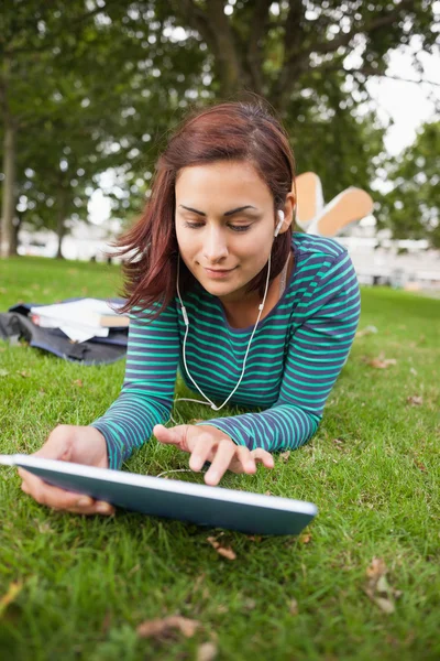Gelegenheitsstudent liegt mit Tablet im Gras — Stockfoto