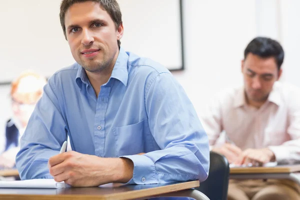 Mature students taking notes in classroom — Stock Photo, Image
