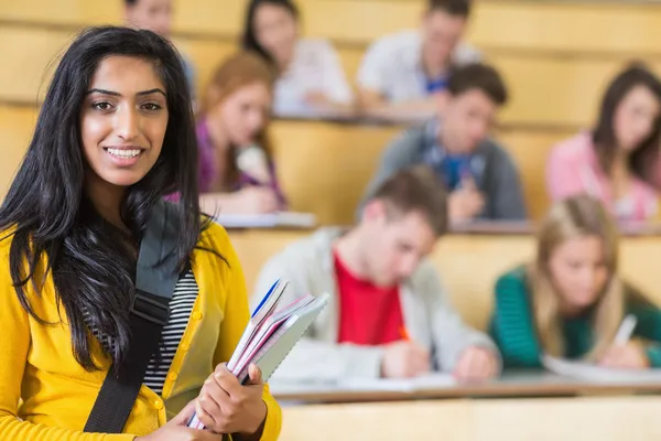 Smiling female with students sitting at the lecture hall — Stock Photo, Image