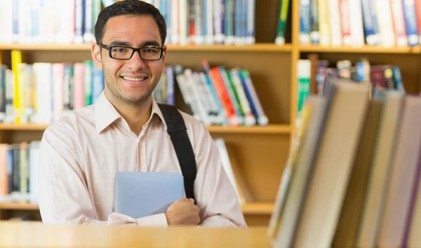 Glimlachend volwassen student met tablet pc in bibliotheek — Stockfoto