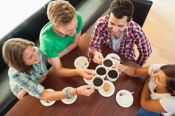 Cuatro estudiantes felices tomando una taza de café charlando —  Fotos de Stock