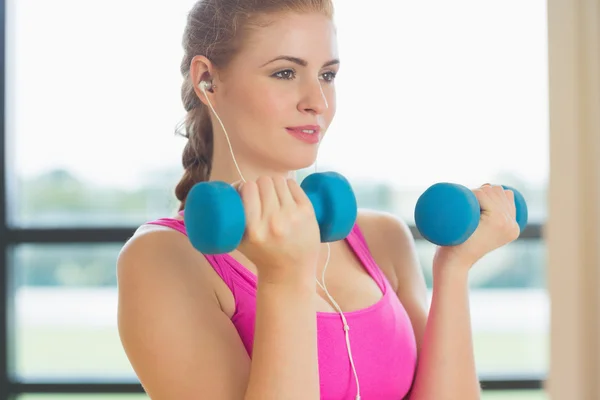 Vrouw uitoefenen met halters in fitness-studio — Stockfoto