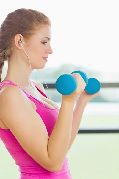 Passar kvinna tränar med hantlar i fitnesstudio — Stockfoto