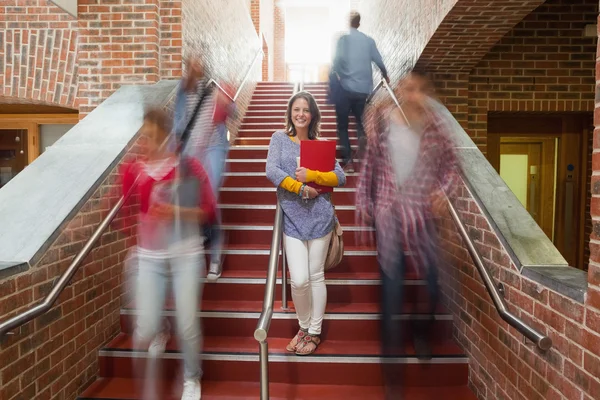 Casual lachende student staande op de trap — Stockfoto