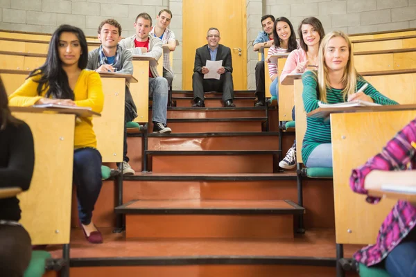 Rlegant öğretmen öğrencilerle konferans Salonu'nda oturan — Stok fotoğraf
