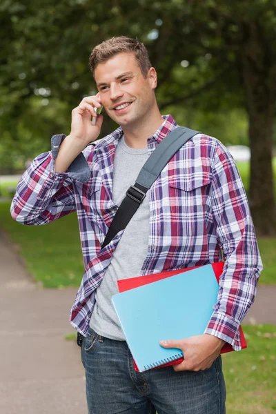 Knappe lachende student permanent en bellen — Stockfoto