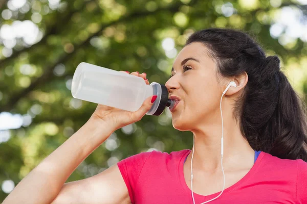 Sporty woman drinking out of a bottle — Stock Photo, Image