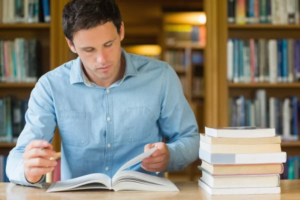 Allvarliga mogen student som studerar på biblioteket skrivbord — Stockfoto