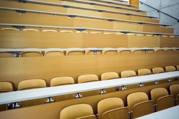 Asientos vacíos con mesas en una sala de conferencias — Foto de Stock