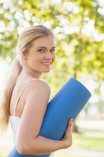 Gorgeous blonde woman posing holding an exercise mat — Stock Photo, Image
