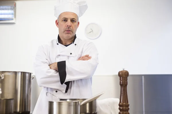 Jefe de cocina serio de pie brazos cruzados detrás de olla —  Fotos de Stock