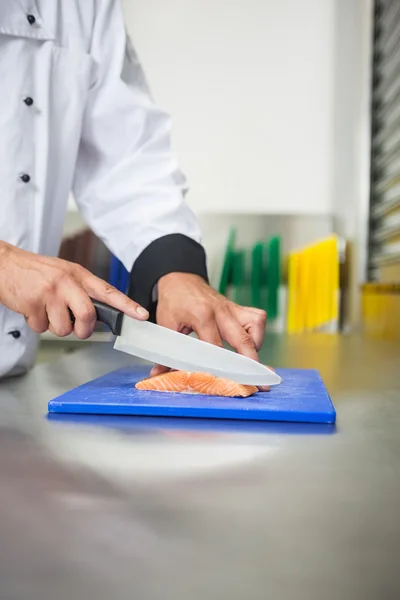 Chef slicing raw salmon with knife — Stock Photo, Image