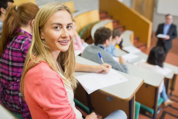 Leende kvinna med studenter och lärare vid föreläsningssal — Stockfoto