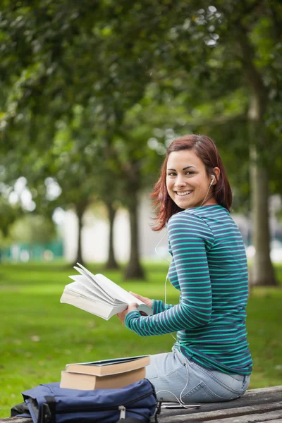 Glückliche beiläufige Studentin sitzt auf Bank lesen — Stockfoto